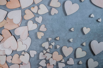A lot of wooden decorative hearts on a gray background. Valentine's Day Concept.