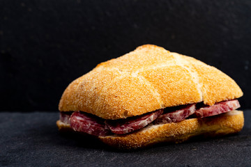 Panino con salamino su sfondo nero