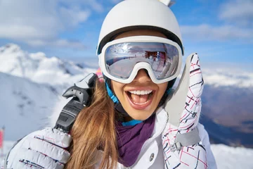 Papier Peint photo Sports dhiver Portrait of beautiful woman with ski and ski suit in winter mountain.