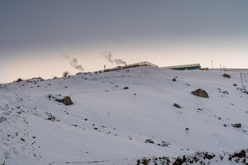 At a snowy mountain peak. Half of Mountain range covered with snow.