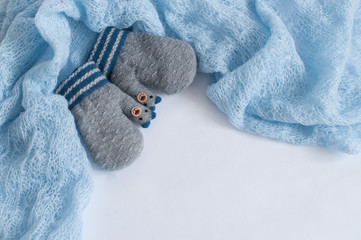 Fototapeta na wymiar Pair of grey knitted mittens on a white background