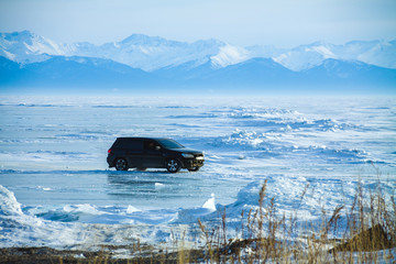 A car on the Baikal lake in winter by day