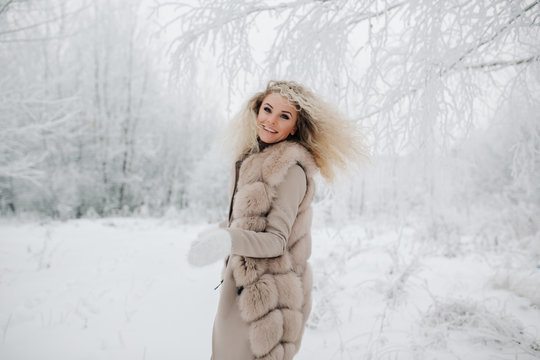 Image of happy blonde woman on walk in winter forest