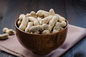 Peanuts in the peel on a dark background.