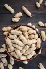 Peanuts in the peel on a dark background.