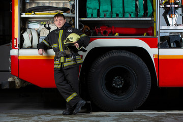 Image of young fireman man near fire truck