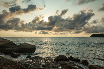 Fototapeta na wymiar waves striking at the rocks of Каtа beach on the Phuket island of Thailand at sunset