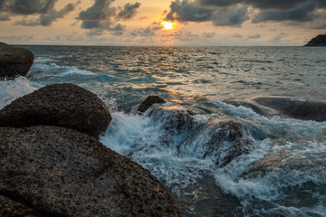waves striking at the rocks of Kata beach on the Phuket island of Thailand at sunset