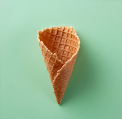 Ice cream cone on green pastel background. Art. Flat lay