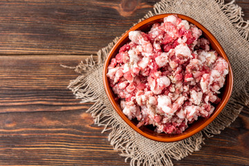 Raw minced meat on dark wooden background.