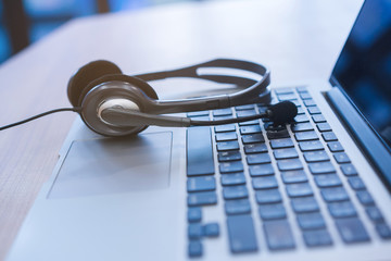 close up soft focus headphone call centre hotline at computer office help desk for background...