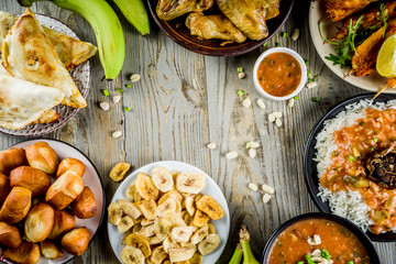 West african food concept. Traditional Wset African dishes assortment - peanut soup, jollof rice, grilled chicken wings, dry fried bananas plantains, nigerian chicken kebabs, meat pies, top view