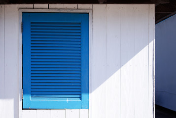 Fototapeta na wymiar blue window and white wood wall background, vintage.