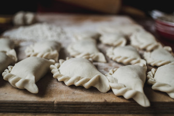 Homemade food -making traditional Polish pierogi - closeup. Soft moody tones.