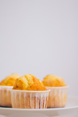 Orange muffins in a cake stand, on a white background. Minimalism