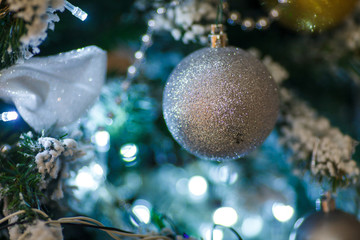 white Christmas tree ball on a pine tree with a garland