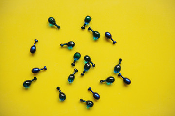 Fillers or capsules with hyaluronic acid on a yellow background. Skin care and facial health.