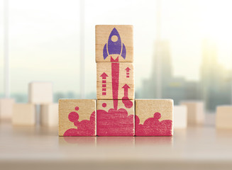 Business start up, start, new project or new idea concept. Wooden blocks with launching rocket...