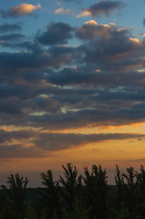 Landscape with dramatic light - beautiful golden sunset with saturated sky and clouds.