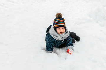 Fototapeta na wymiar Child playing in a snow in winter. baby playing with snow. baby playing with snow. 