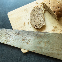 piece of stale bread sawed off from a loaf of hacksaw - obrazy, fototapety, plakaty