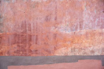 Fototapeta na wymiar Pink multicolored weathered outdoor wall. Urban background.