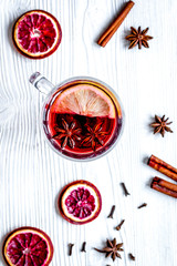 mulled wine with spices in cup wooden background top view