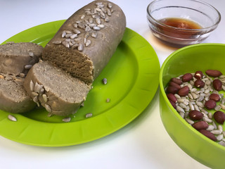 Halva, cooked at home. Nearby are the ingredients for its preparation of roasted peanuts, seeds and honey.