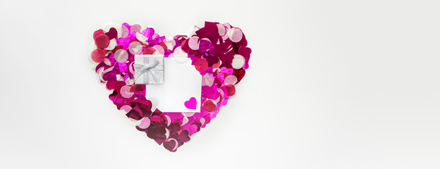 Obraz na płótnie Canvas Valentines Day Heart shape made of pink glitter hearts with copy space paper card note on White Background. Valentine's day concept romantic celebration, wedding. Flat lay, horizontal. Love concept.