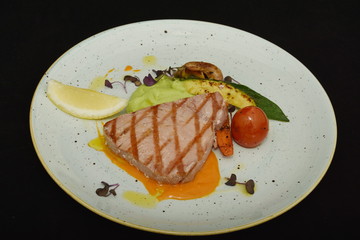 Fresh steak with avocado, lemon, mushroom on white plate