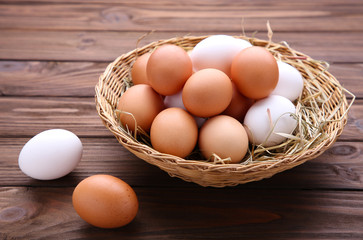 Fresh Chicken eggs in basket on brown background