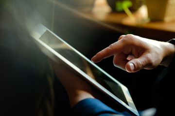 A man works in a tablet with a natural light source