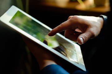 A man works in a tablet with a natural light source