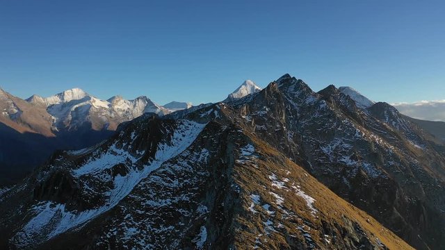 Flying the drone over austrian mountains. Snow already covered this mountains in october.