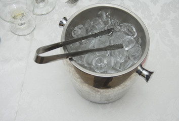 ice cubes in the bucket with tongs