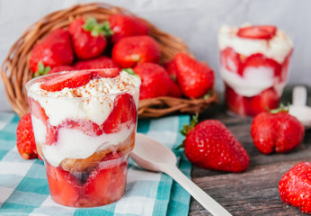 Strawberries with cream or tiramisu in small glasses 