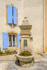 Fototapeta na wymiar Ancienne fontaine et façade de maison en Provence, France.