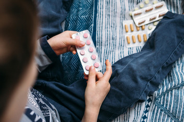 A small child holds a plate with pills in his hands. danger situation