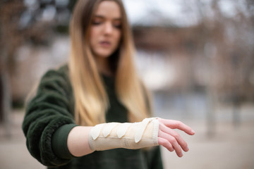 Young woman touching injured arm in park