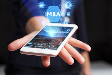 The concept of business, technology, the Internet and the network. A young entrepreneur working on a virtual screen of the future and sees the inscription: MBA