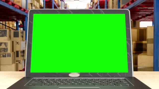 Laptop with green screen on table with blur store factory background  with  track green screen