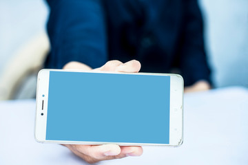 Close up of shot of single hand of a business man wearing a blue colored suit isolated on white using a smart phone with single hand concept of working on a project at a time.