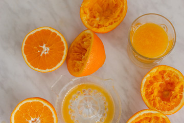 Oranges and squeezer on marble table