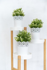 White flower pot with bright green fake trees