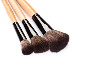 Fototapeta premium Various makeup brushes isolated over white. wooden makeup brushes. Duo fibre foundation makeup brush. Style. Fashion. Visage. Cosmetics.