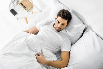 top view of handsome man resting in bed in the morning