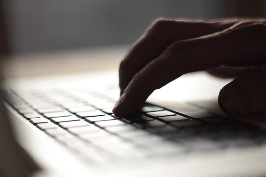 close up. blurred image of male typing on laptop keyboard