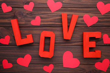 Red letters love on brown wooden background. LOVE word.