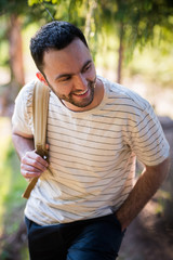 Young man hiking smiling happy portrait. Male hiker walking in forest