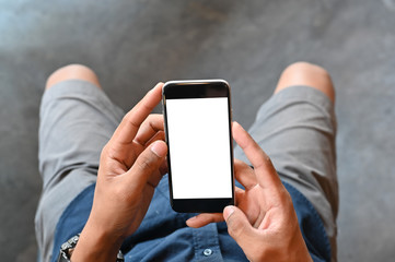 Closeup man hands holding smart phone with blank copy space screen for your text message or information content, male reading text message on cell telephone during in urban setting.